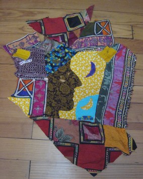 multi-color fabric partial quilt front, shape of face and moons, etc.